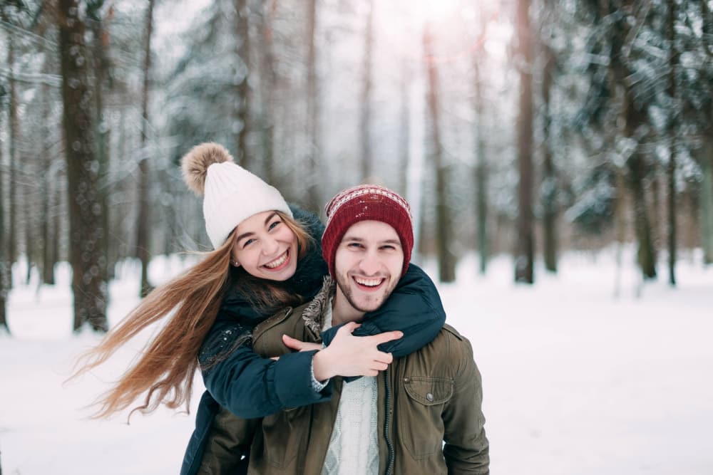 A young couple enjoying the winter wonderland, with one of the best weekend getaways in Upstate New York