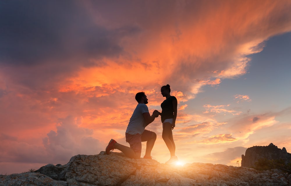 Romantic Getaways in the Adirondacks, man asking a woman to marry him on a hike in upstate New York at sunset