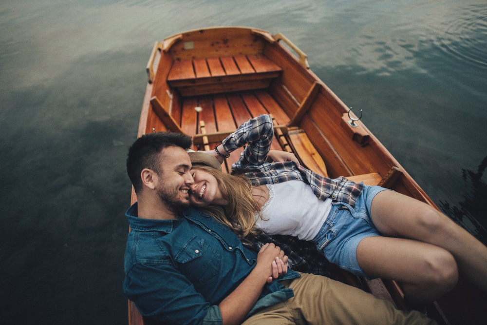 Romantic Getaways in Upstate NY, photo of a happy couple on a boat on the lake