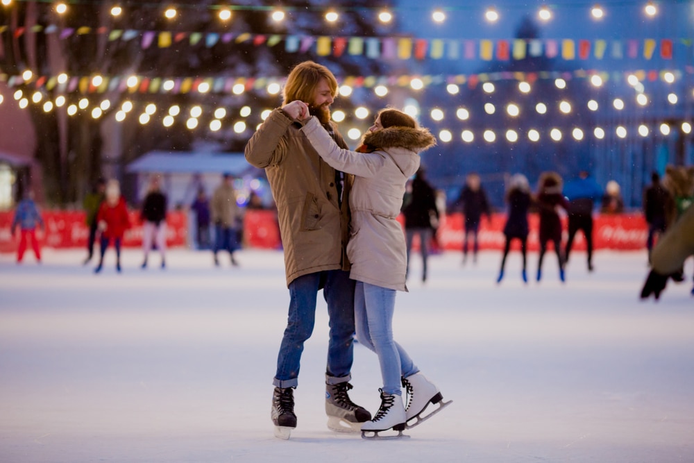 One of the best things to do in Upstate NY is visit the Ice Castles Lake George, couple skating on an ice rink