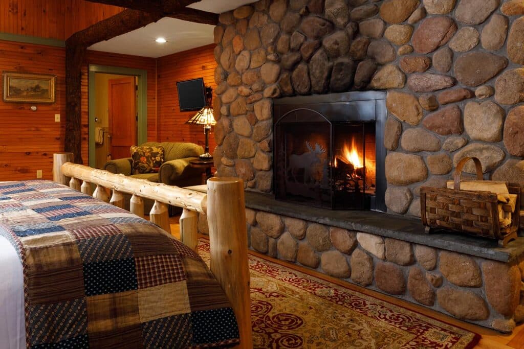 The Great Lakes Room with river rock fireplace at the Friends Lake Inn, one of the best Boutique Hotels in Upstate NY.